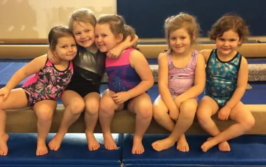 a group of girls sitting on a bench