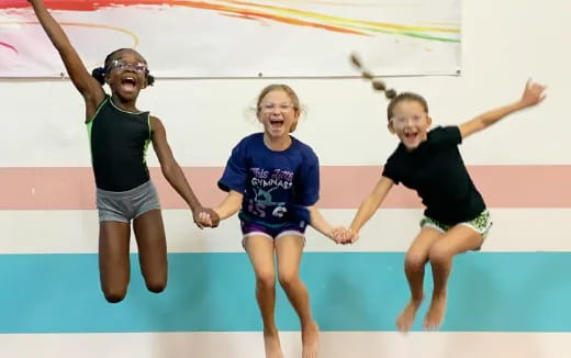 a group of girls jumping in a pool