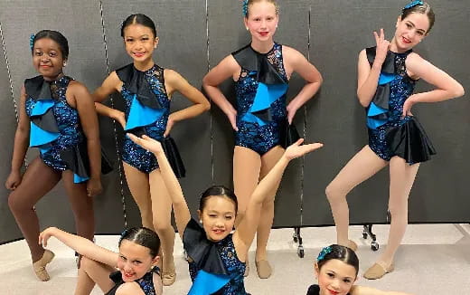 a group of women in blue and black dresses