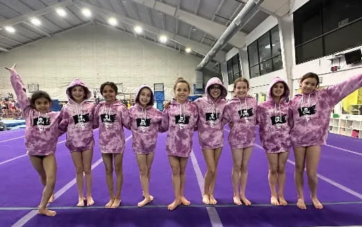 a group of girls in pink and white outfits on a stage