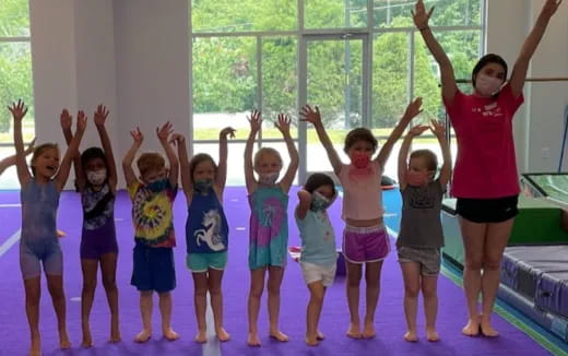 a group of children raising their hands