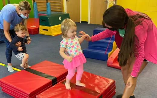 a person and children playing on a mat