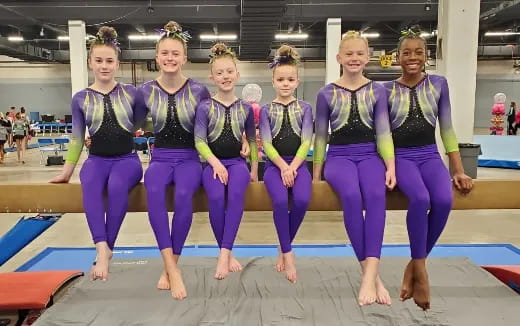 a group of women in leotards posing for a photo