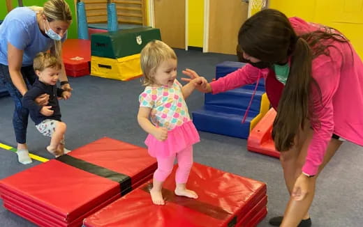 a person and children playing on a mat