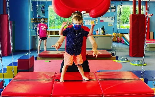 a boy wearing a mask and holding a red ball