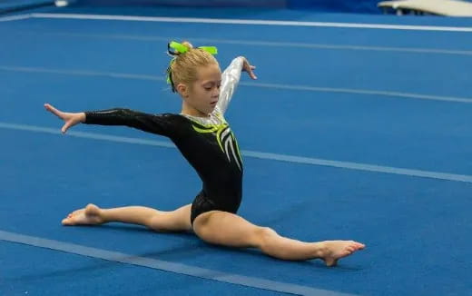 a woman in a leotard on a blue mat