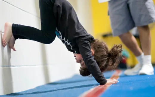 a person doing a handstand on a mat