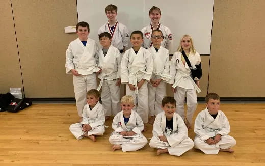 a group of people in white karate uniforms