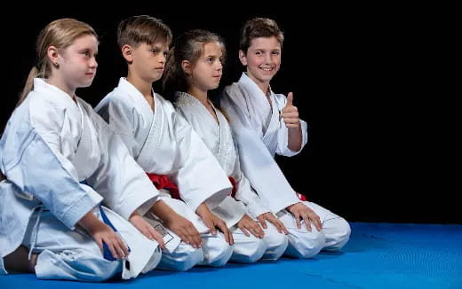 a group of people in white karate uniforms