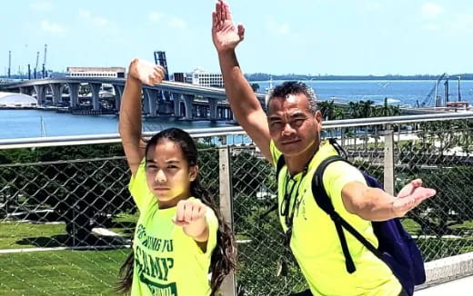 a person and a boy posing for a picture with their arms raised