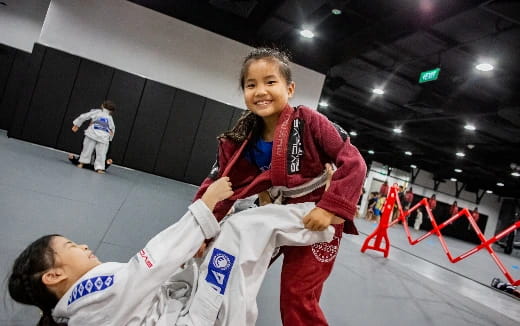a person holding a girl in a karate uniform