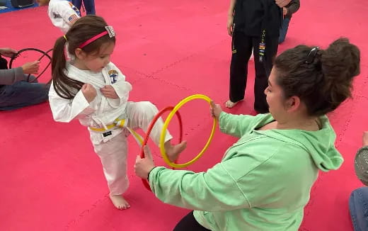 a couple of young girls playing with a hula hoop