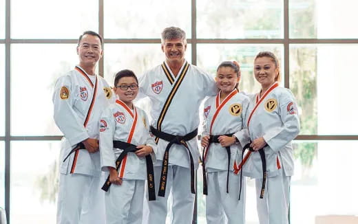a group of people in white lab coats holding a ribbon