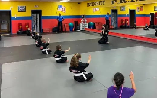 a group of people sitting on the floor in a gym