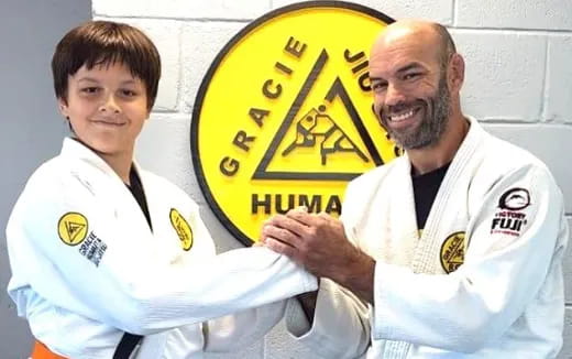 a person and a boy holding a yellow and black sign