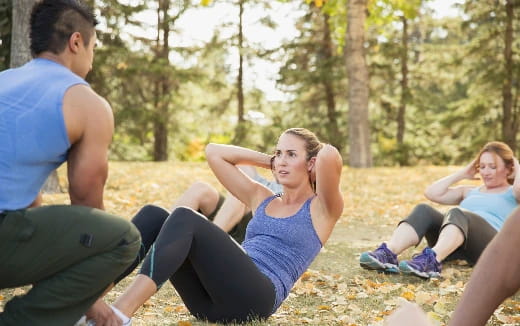 a group of people sitting on the ground in a park
