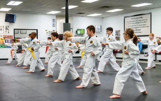 a group of people in white karate uniforms