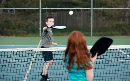 a couple of kids playing tennis