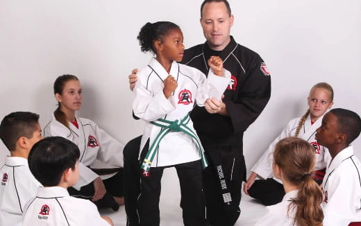 a man and woman dancing with a group of children