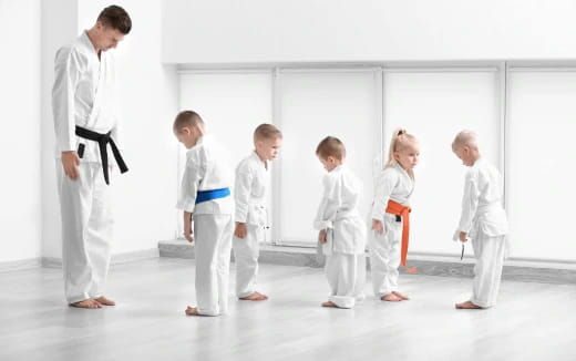 a group of people in white karate uniforms