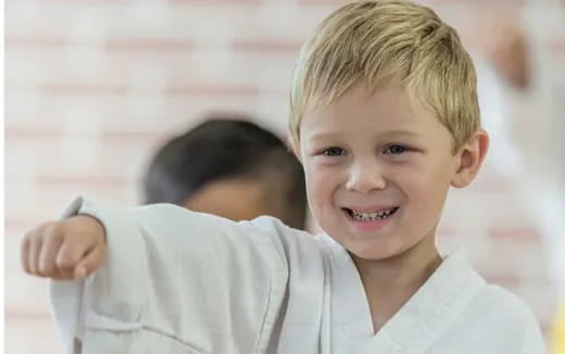 a boy smiling with his hand on his shoulder