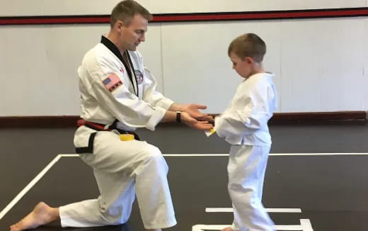 a man in a karate uniform and a boy in a karate uniform