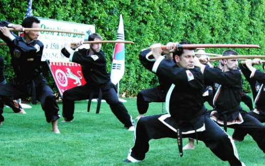 a group of men in black uniforms holding rifles
