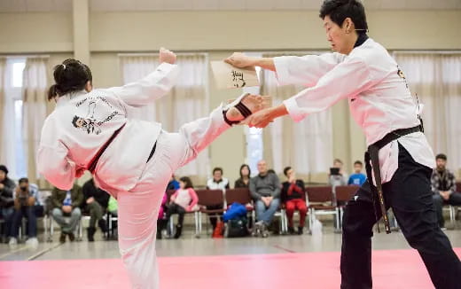 a man and a woman in karate uniforms in front of a crowd