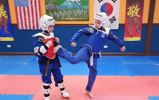 a person and a boy wearing helmets and holding a flag