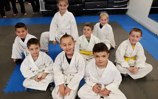 a group of children in white uniforms