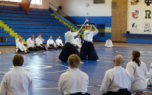 a person holding a sword in front of a group of people