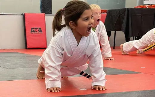 a couple of children in karate uniforms