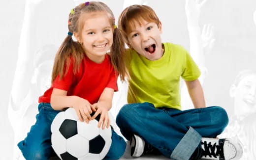 a couple of kids sitting on a bed and laughing