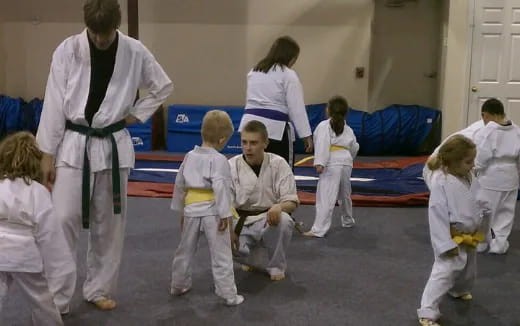 a group of people in white karate uniforms