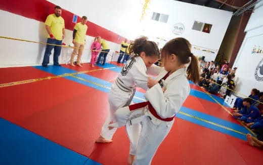 a couple of girls in karate uniforms