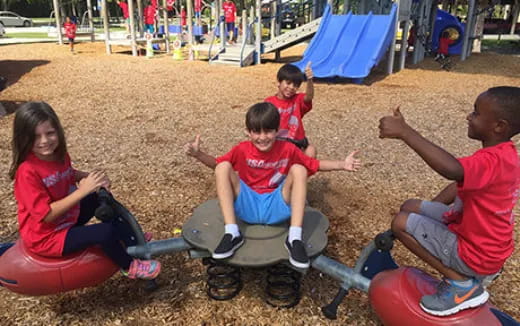 a group of children sitting on a playground toy