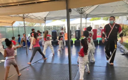a man and a group of children dancing under a tent