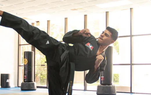 a man in a uniform leaning on a metal pole