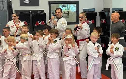 a group of children in white karate uniforms