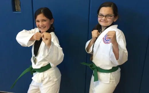 a couple of girls in karate uniforms