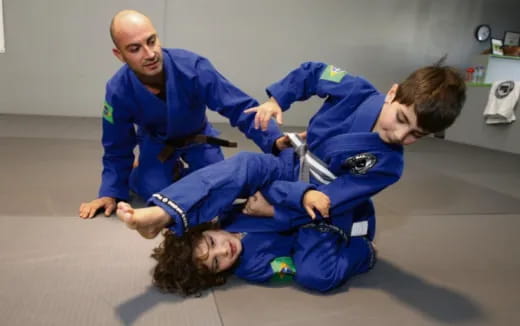 a person holding a boy in a karate uniform