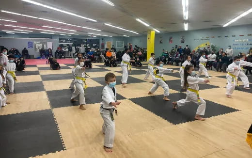 a group of people in white karate uniforms in a room