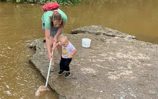 a person and a child standing in a river