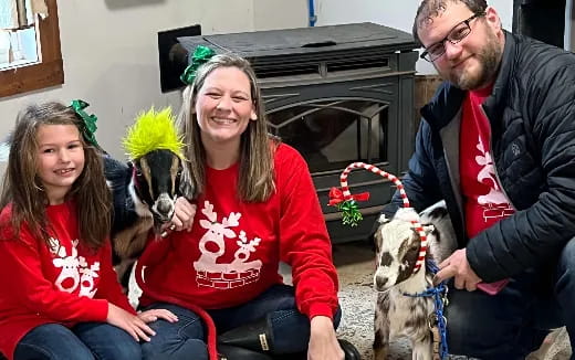 a group of people sitting on a couch with dogs