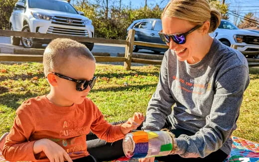 a person and a boy sitting on the grass