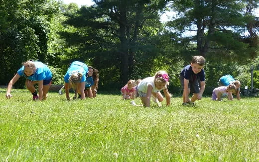 a group of children playing in the grass