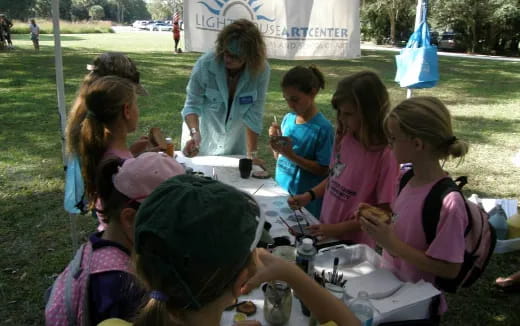 a group of children sitting at a table outside