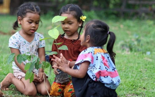 a group of young girls sitting on grass