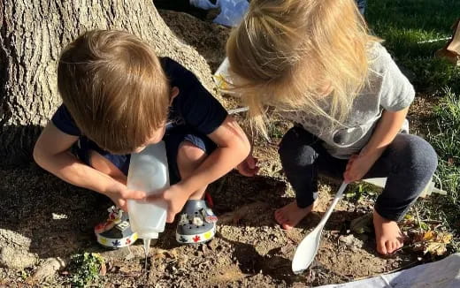 a couple of children digging in the dirt