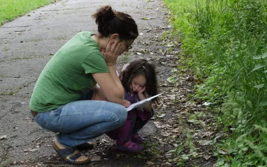 a person and a girl sitting on a path